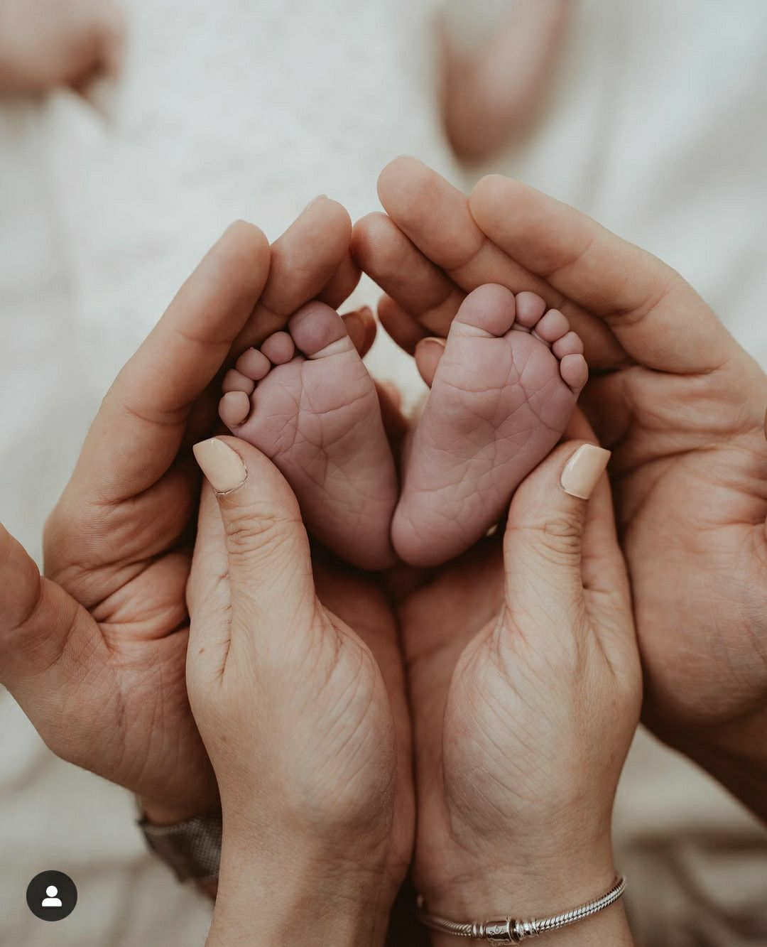 Newborn baby's feet held gently in parents' hands